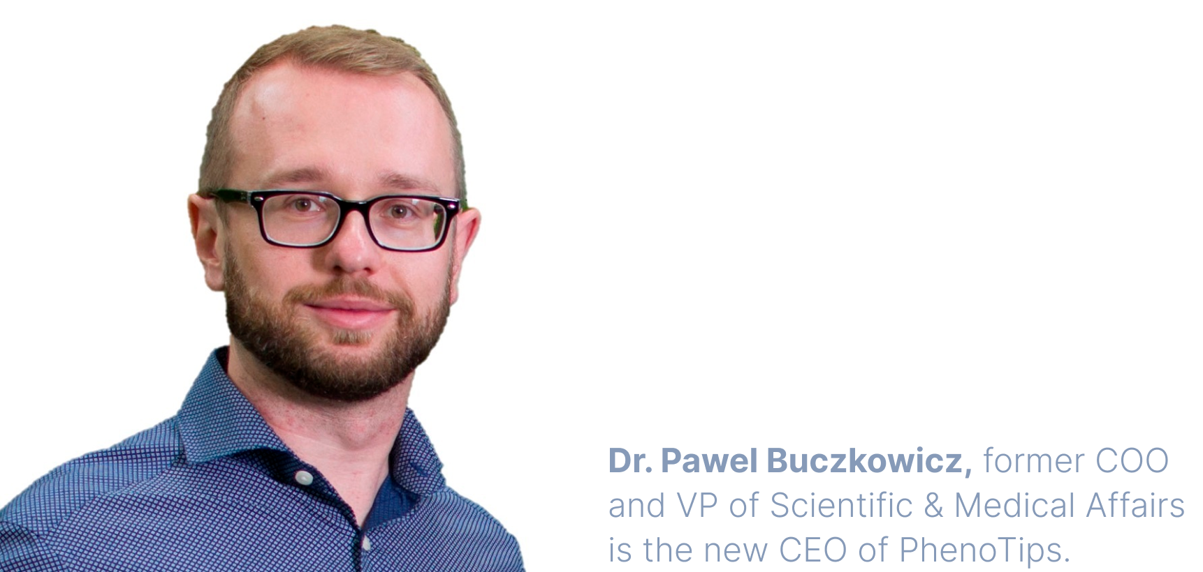 A professional headshot of Dr. Pawel Buczkowicz, a white adult man with short dark-blonde hair, a trim beard, and glasses. He smiles warmly at the camera while wearing a blue polkadotted dress shirt and standing in front of a white backdrop.